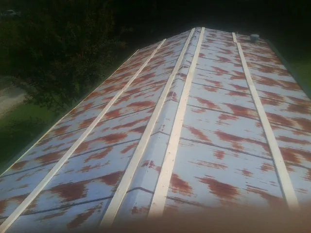 Rusted metal roof panels with new wood purlins before replacement — Storm Damage Roof Repair in Buena by Roofing Brothers